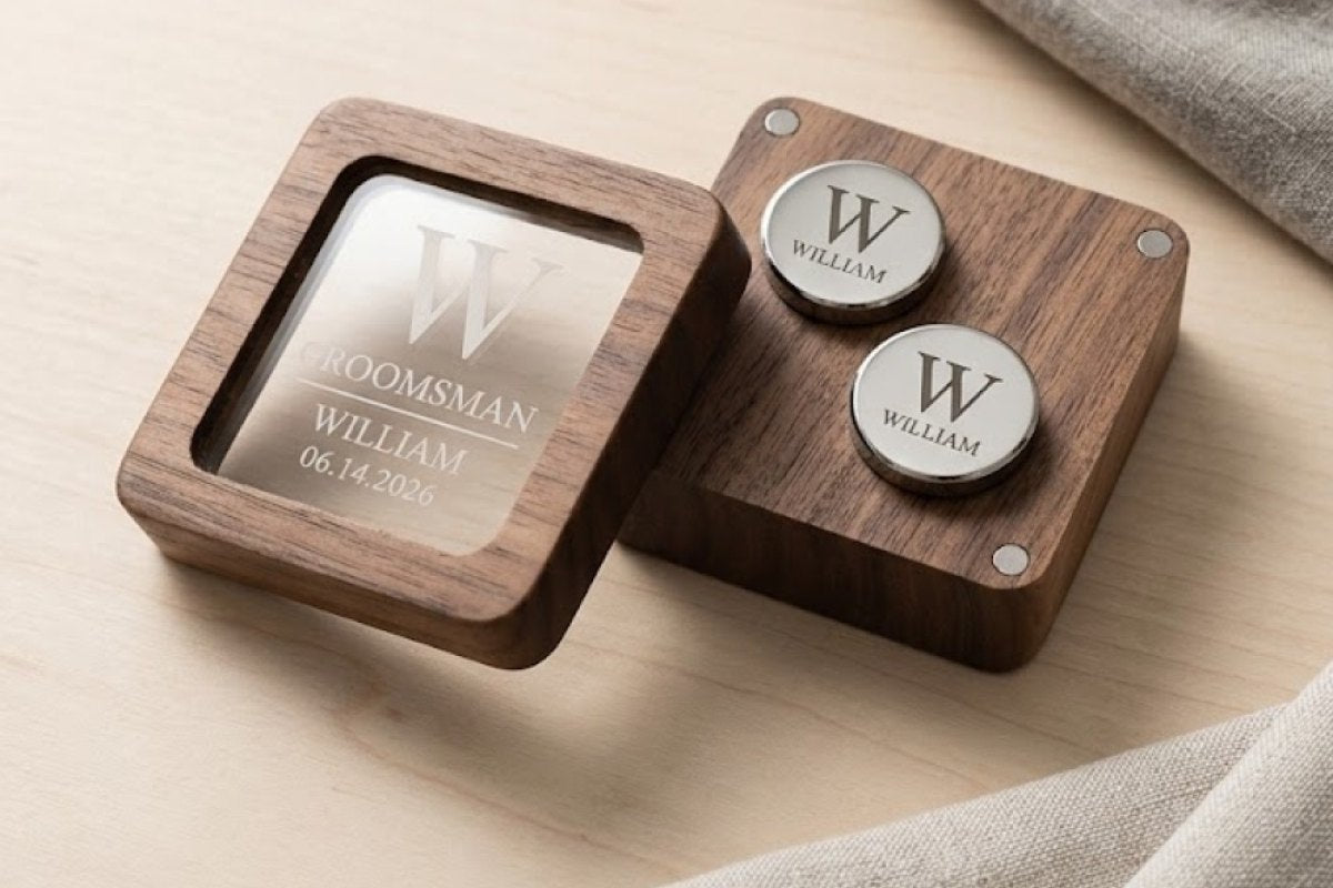A pair of engraved cufflinks in an open walnut box