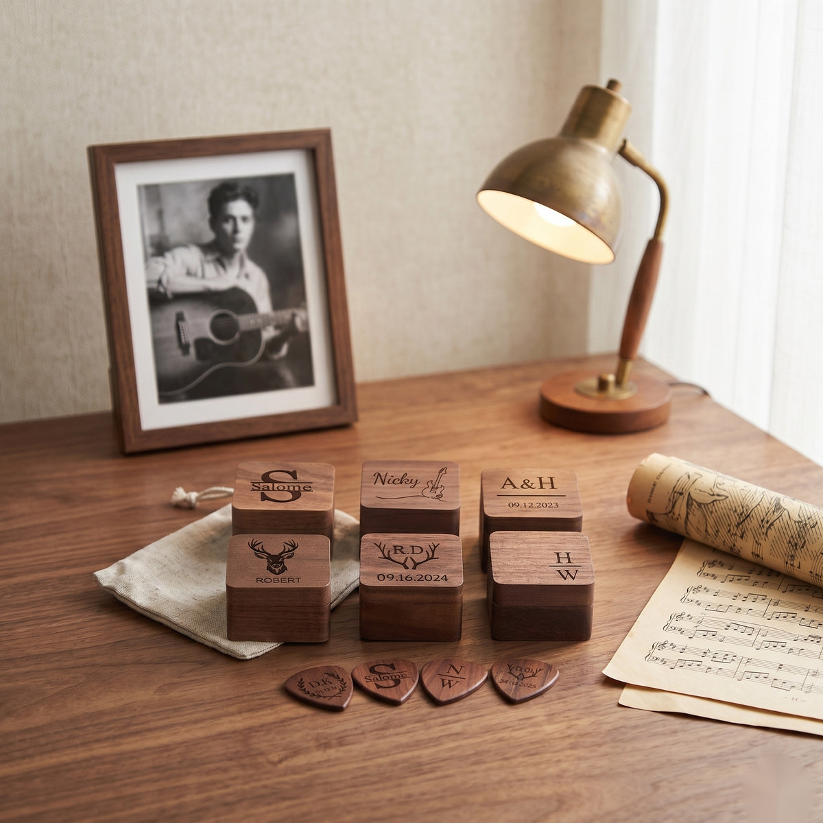 Personalized guitar pick boxes on a musicians desk with sheet music - MAHOOSIVE keepsake