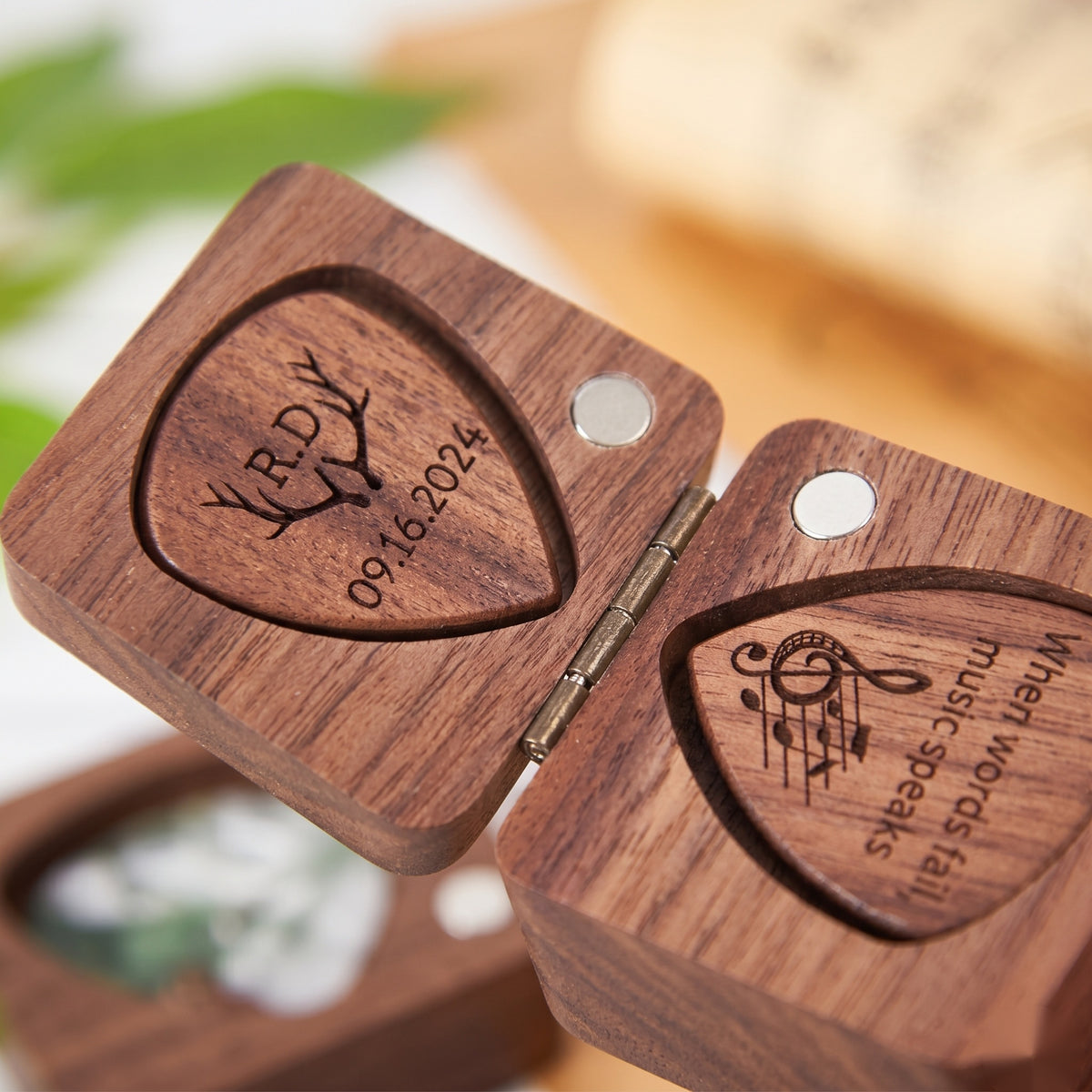 Close-up of engraved wooden guitar picks in a walnut pick box - when words fail music speaks